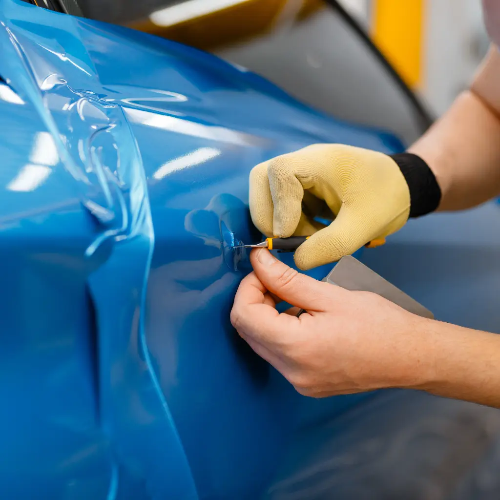 Heat-assisted vinyl wrapping on curved car panels, explaining how car wraps conform to vehicle body shapes