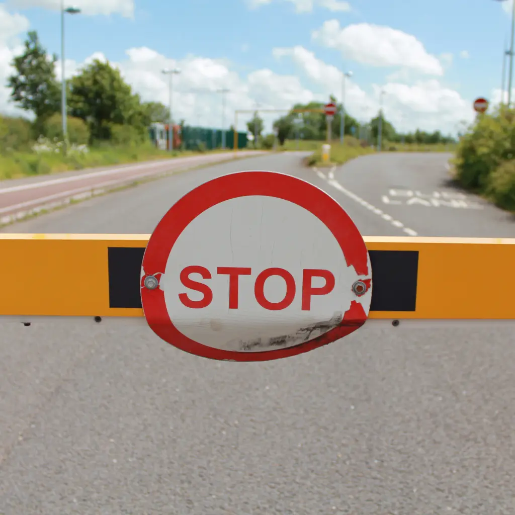 What is outdoor signage shown with road barrier stop sign example used for traffic control and external safety display