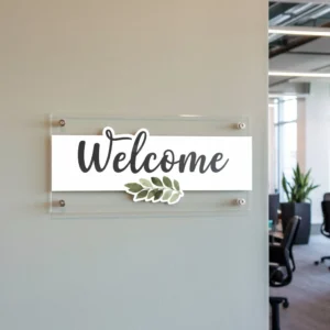 acrylic wall plaque with printed welcome sign mounted on standoffs in a modern UK office corridor