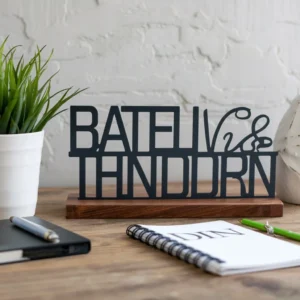 Office desk plaques featuring black metal personalised lettering on solid wooden base for professional workspace identification