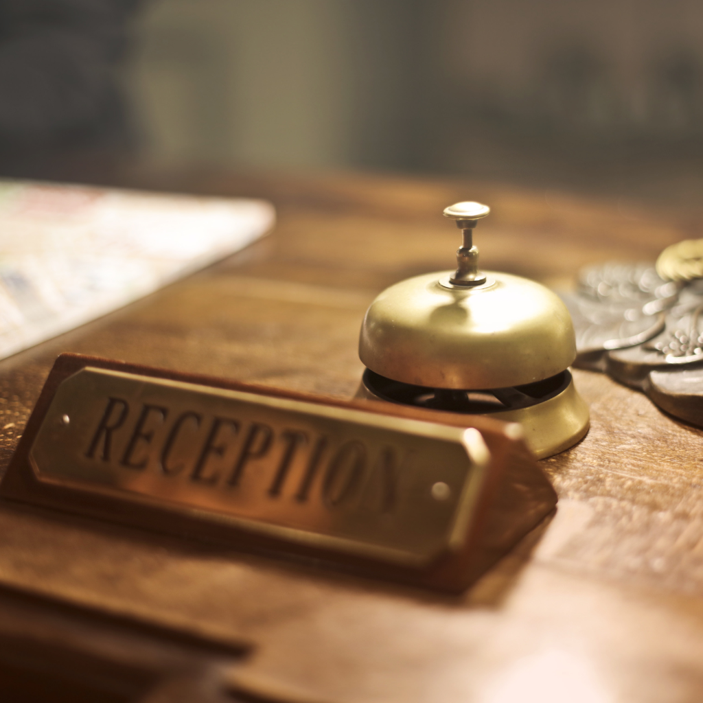 Office desk plaque in brass finish with engraved reception sign and traditional service bell for UK front desk use